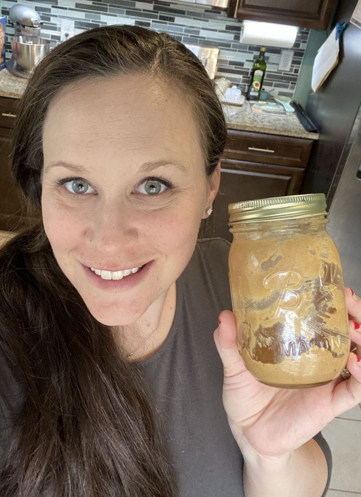 Housewife holding a jar of homemade peanut butter